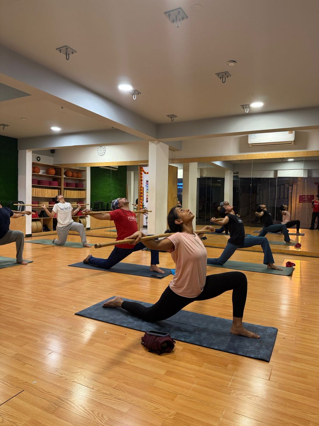 Group class flowing through a guided lunge sequence at Hamsa
