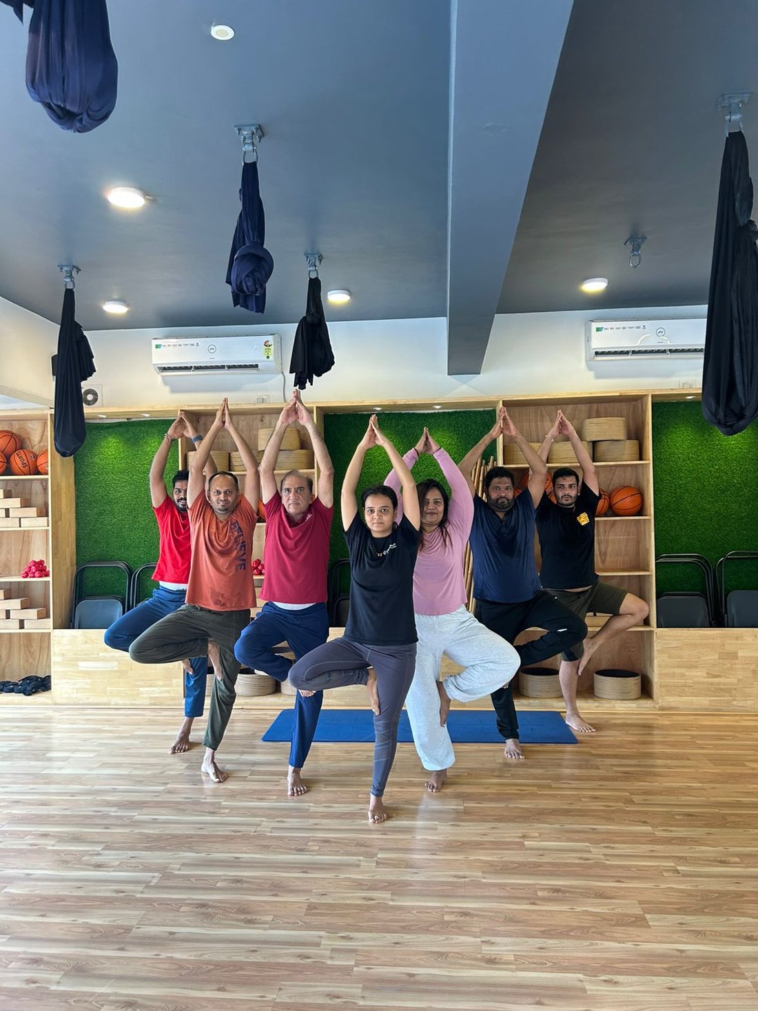 Students in tree pose during a community class at Hamsa